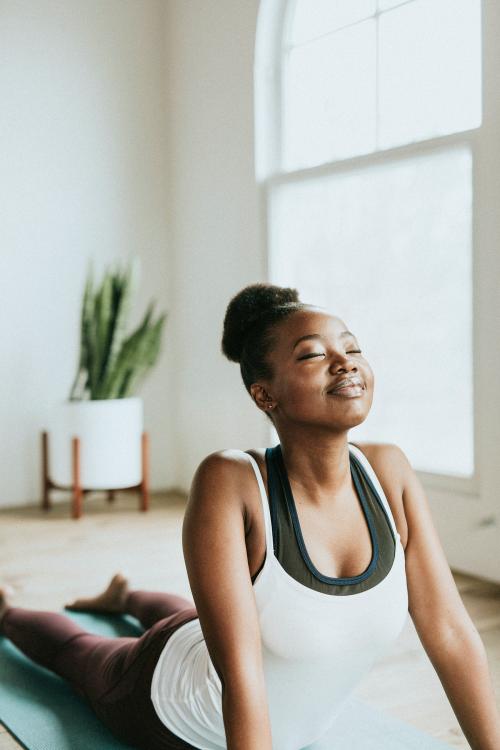 Black lady doing a Bhujangasana pose - 1226955