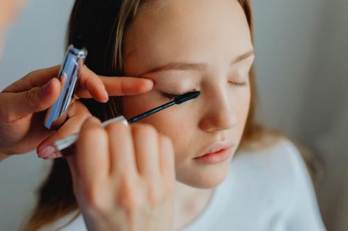 Beauty blogger applying mascara to her model - 1232040