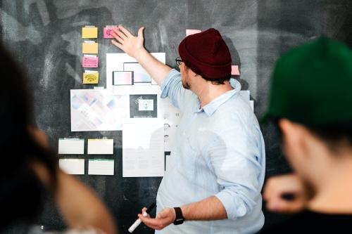 Leader in a startup company brainstorming using a blackboard - 2012683