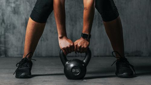 Sportive woman getting ready to lift a kettlebell - 1222496