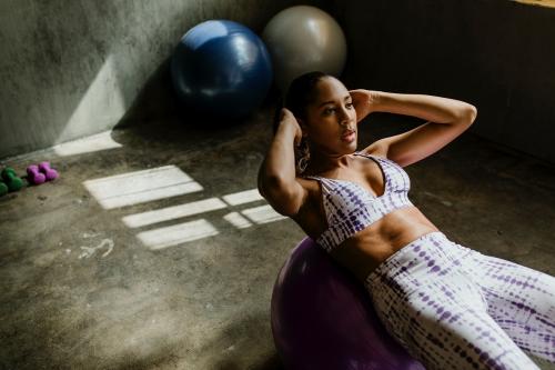 Sportive woman doing the sit-ups on a balance ball - 1222549