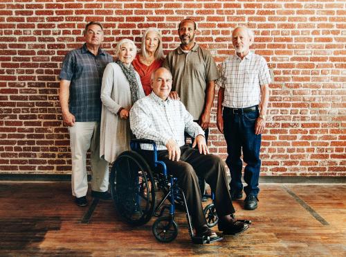 Happy elderly man on a wheelchair with friends - 1223756