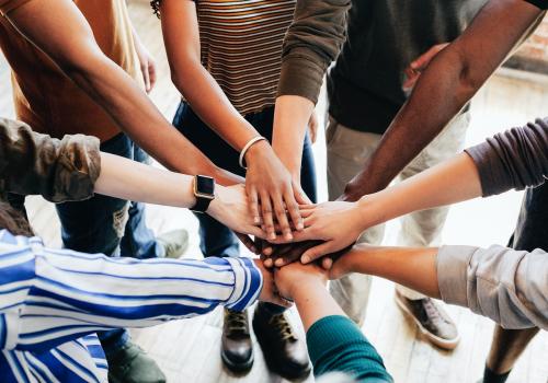 Group of diverse people stacking hands in the middle - 1223777