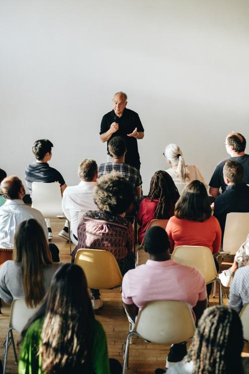 Elderly man speaking on a microphone in a seminar - 1223830