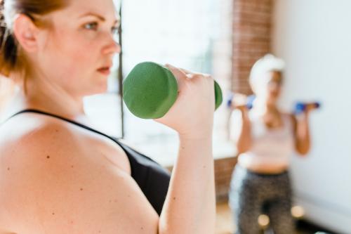 Sporty woman using a dumbbell - 1225157