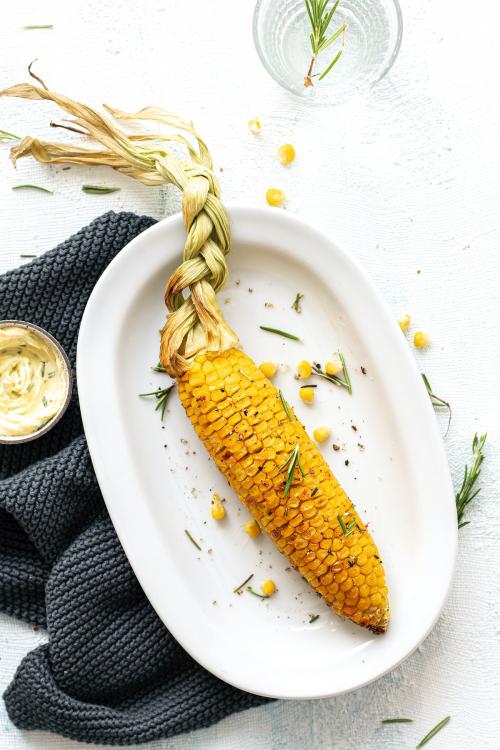 Fresh corn on the cob with organic rosemary leaves - 1225292