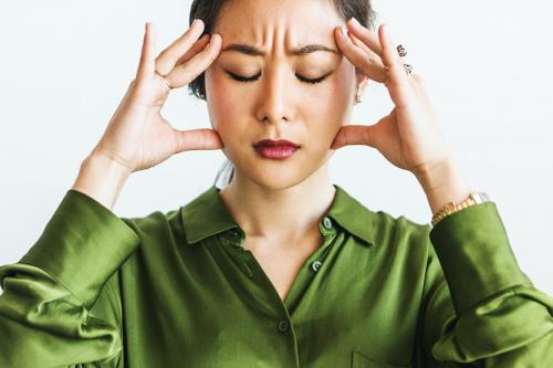 Stressed woman holding her forehead - 1226487