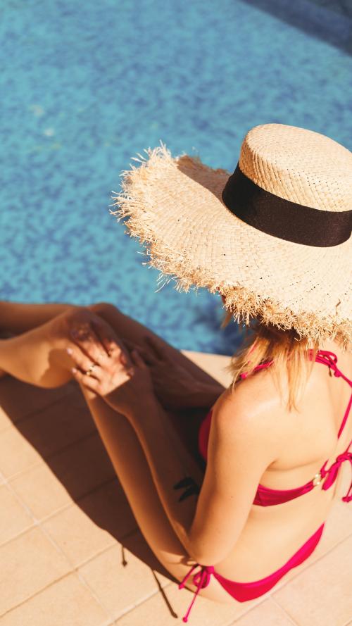 Woman in a pink bikini sitting by the pool mobile phone wallpaper - 1228371