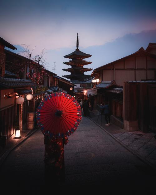 Woman in a kimono walking with a red umbrella at Yasaka Pagoda in Kyoto, Japan - 843883