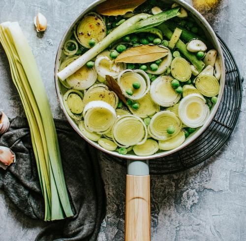 Cooked leeks with peas in a pot - 893623