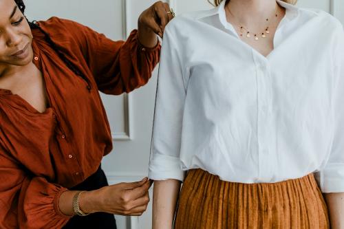 Fashion stylist measuring a customer's arm - 1220814