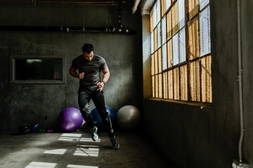 Sportive man doing a side to side jump in a gym - 1222552