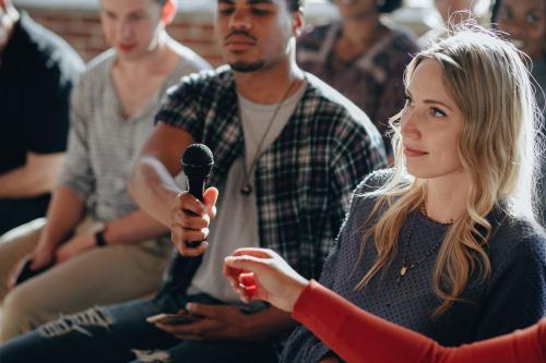 Man handing a microphone to a woman - 1223812