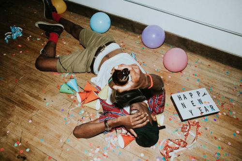 Man laying down on the floor at a party - 1225199