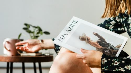 Woman with a cup of tea reading a magazine - 1226385