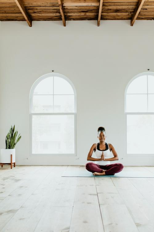 Black lady doing a Sukhasana yoga pose - 1226894