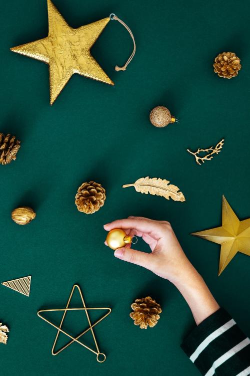 Woman making a Christmas tree with gold ornaments aerial view - 1231721