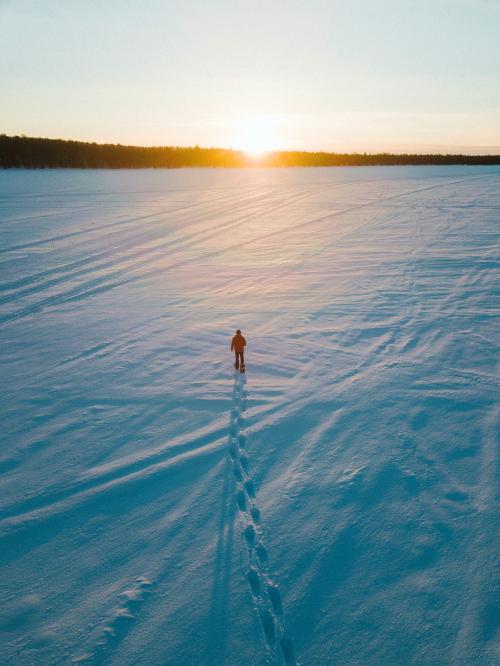 Man walking on the snow while admiring the sunset - 846354