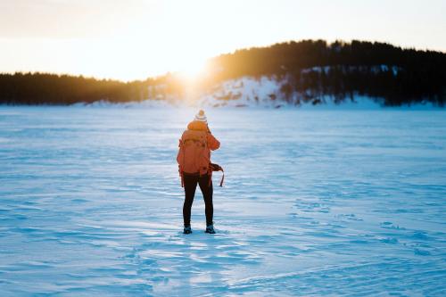 Woman with a backpack trekking through the snow - 846375