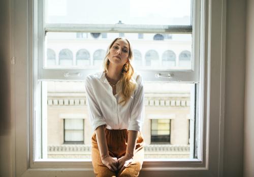 Woman sitting on a window sill - 1220900