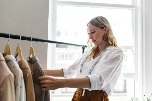 Young female designer in a boutique - 1220907