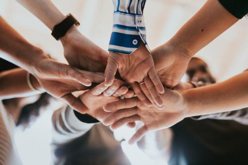 Group of diverse people stacking hands in the middle - 1223822