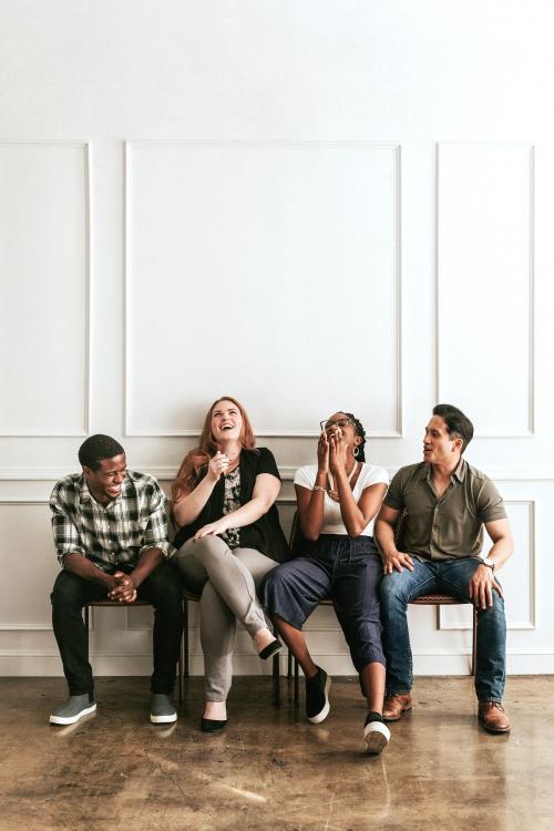 Happy people sitting by a white wall - 1224281