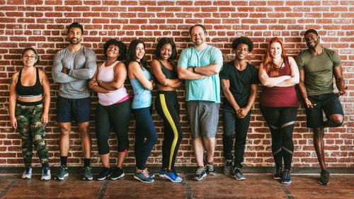 Happy active people standing against a brick wall - 1225093