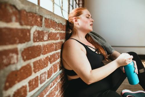 Exhausted woman against a brick wall - 1225139