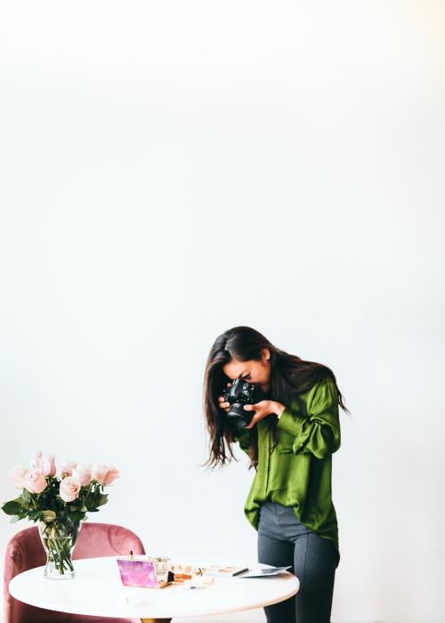 Female photographer shooting beauty products on the table - 1226576