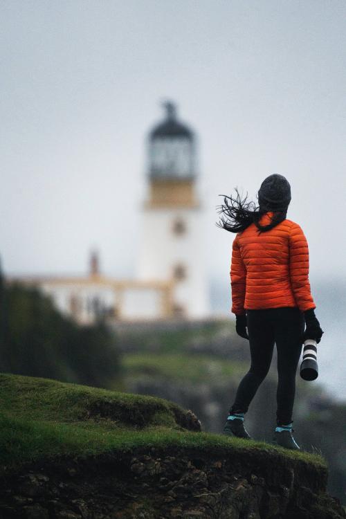 Female photographer at Neist Point Lighthouse, Isle of Skye, Scotland - 1233355