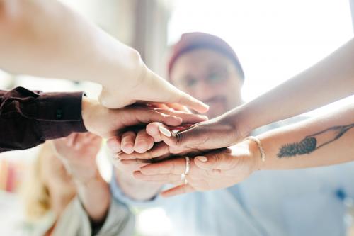 Happy team putting their hands together for success - 2012624