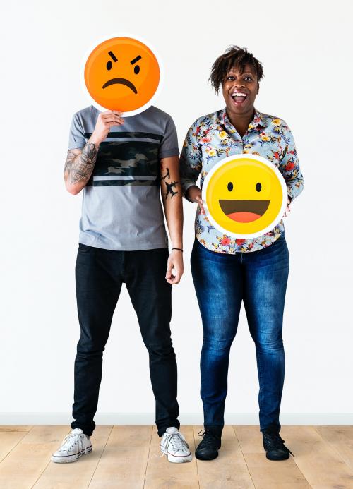 Interracial couple holding an expressive emoticon face facial expression frown and smile relationship issue concept - 414624