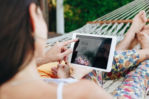 Couple using a tablet in a hammock - 418449