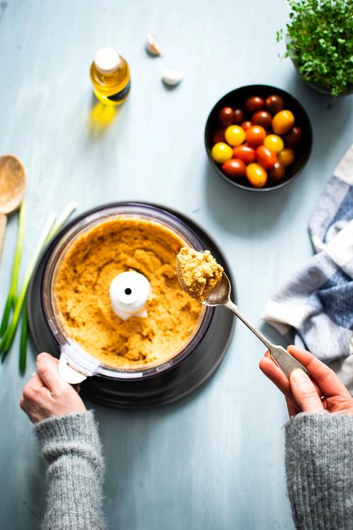 Woman with a spoon of hummus - 893607