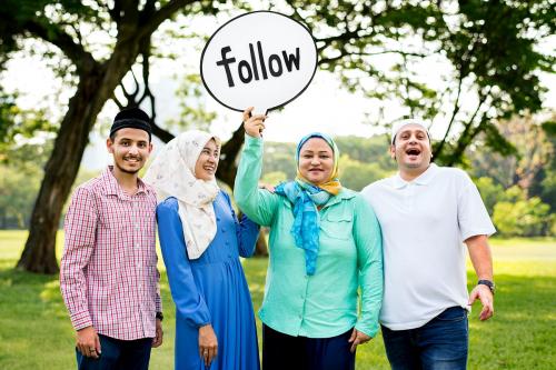 Muslim family holding up a follow sign - 426043