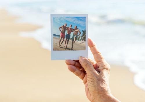 Old lady holding a photograph at the beach - 428699