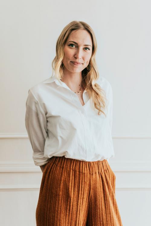 Fashionable woman standing by a white wall - 1220864