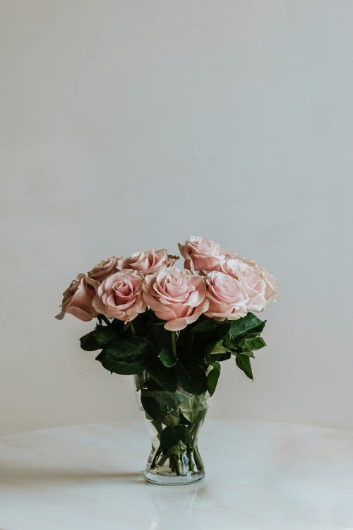 Beautiful pink roses in a vase on a table - 1221527