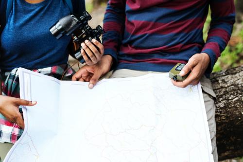 Trekking couple using map and compass in a forest - 442002