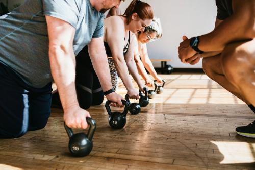 Coach training his students to lift a kettlebell - 1225084