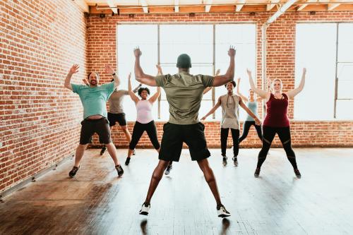 Trainer and his students stretching in a studio - 1225096