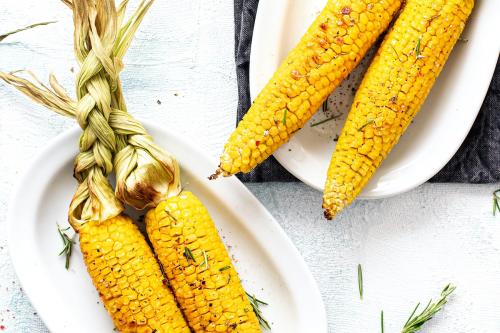 Fresh corn on the cob with organic rosemary leaves - 1225256