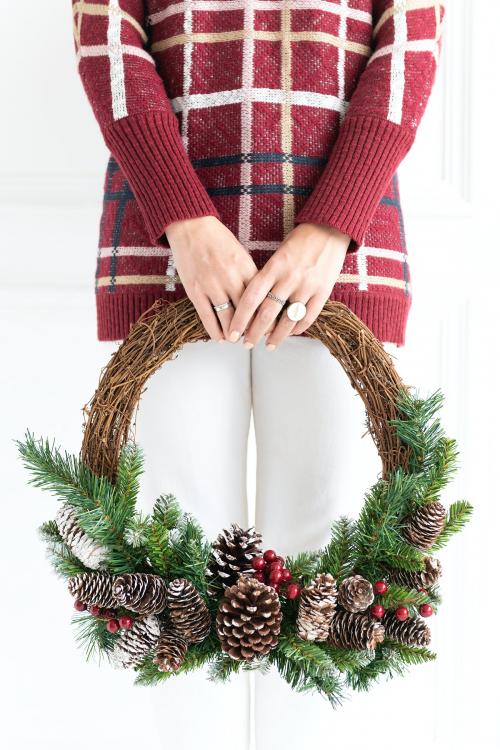 Woman carrying a fresh Christmas wreath - 1231734