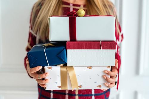 Woman carrying a stack of presents - 1231915