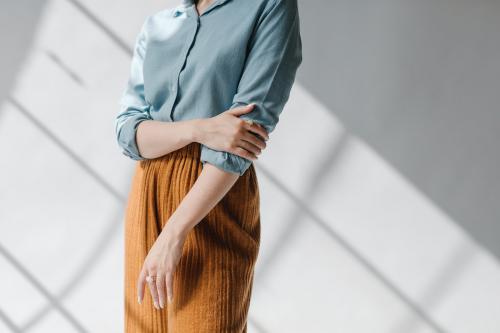 Woman in a blue shirt by the white wall - 1235342