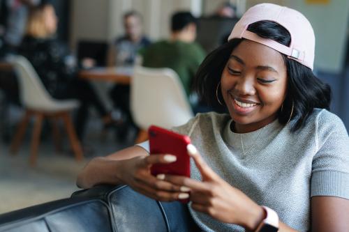 Cheerful black woman texting to her friend - 2012541