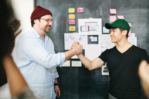 Happy c olleagues holding hands in the office - 2012583