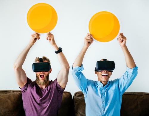 Men enjoying VR goggles on a couch - 391719