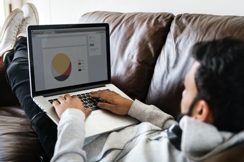 Man using laptop on sofa - 392932